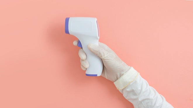 infrared thermometer on pink background